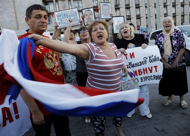 Pro-Russian demonstrators shout slogans in Donetsk, eastern Ukraine, Monday, June 23, 2014. Leaders of the self-proclaimed Donetsk People's Republic and Luhansk People's Republic met Monday with former Ukrainian President Leonid Kuchma, OSCE Ambassador Heidi Tagliavini, and Russian Ambassador in Ukraine Mikhail Zurabov, as insurgents promised Monday to honor a cease-fire declared by the Ukrainian president and engage in more talks to help resolve the conflict.