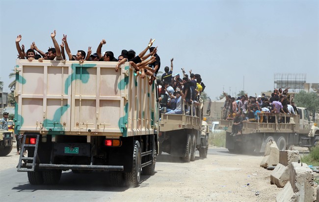 Iraqi men fill military trucks to join the Iraqi army at the main recruiting center in Baghdad, Iraq, Saturday, June. 14, 2014, after authorities urged Iraqis to help battle insurgents. Hundreds of young Iraqi men gripped by religious and nationalistic fervor streamed into volunteer centers across Baghdad Saturday, answering a call by the country's top Shiite cleric to join the fight against Sunni militants advancing in the north.(AP Photo/Karim Kadim).