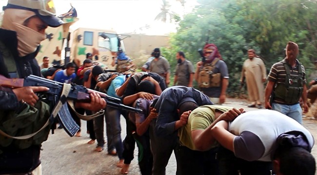 This image posted on a militant website on Saturday, June 14, 2014, which has been verified and is consistent with other AP reporting, appears to show militants from the al-Qaida-inspired Islamic State of Iraq and the Levant (ISIL) leading away captured Iraqi soldiers dressed in plain clothes after taking over a base in Tikrit, Iraq. (AP Photo via militant website).