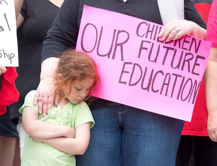 A woman puts her hand on a girls shoulder during an aboriginal protest against the First Nations Education act and missing aboriginal women on Wednesday May 14, 2014 in Ottawa. THE CANADIAN PRESS/Adrian Wyld.