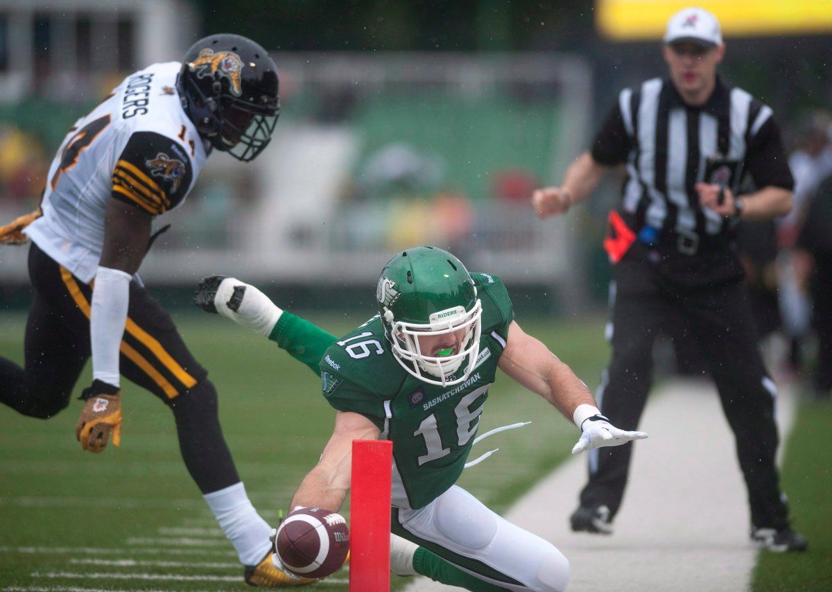Saskatchewan Roughriders wide receiver Brett Swain dives for the end join but is short after being pushed out of bounds by Hamilton Tiger-Cats defensive back James Rogers first quarter of CFL football action in Regina, Sask., Sunday, June 29, 2014.