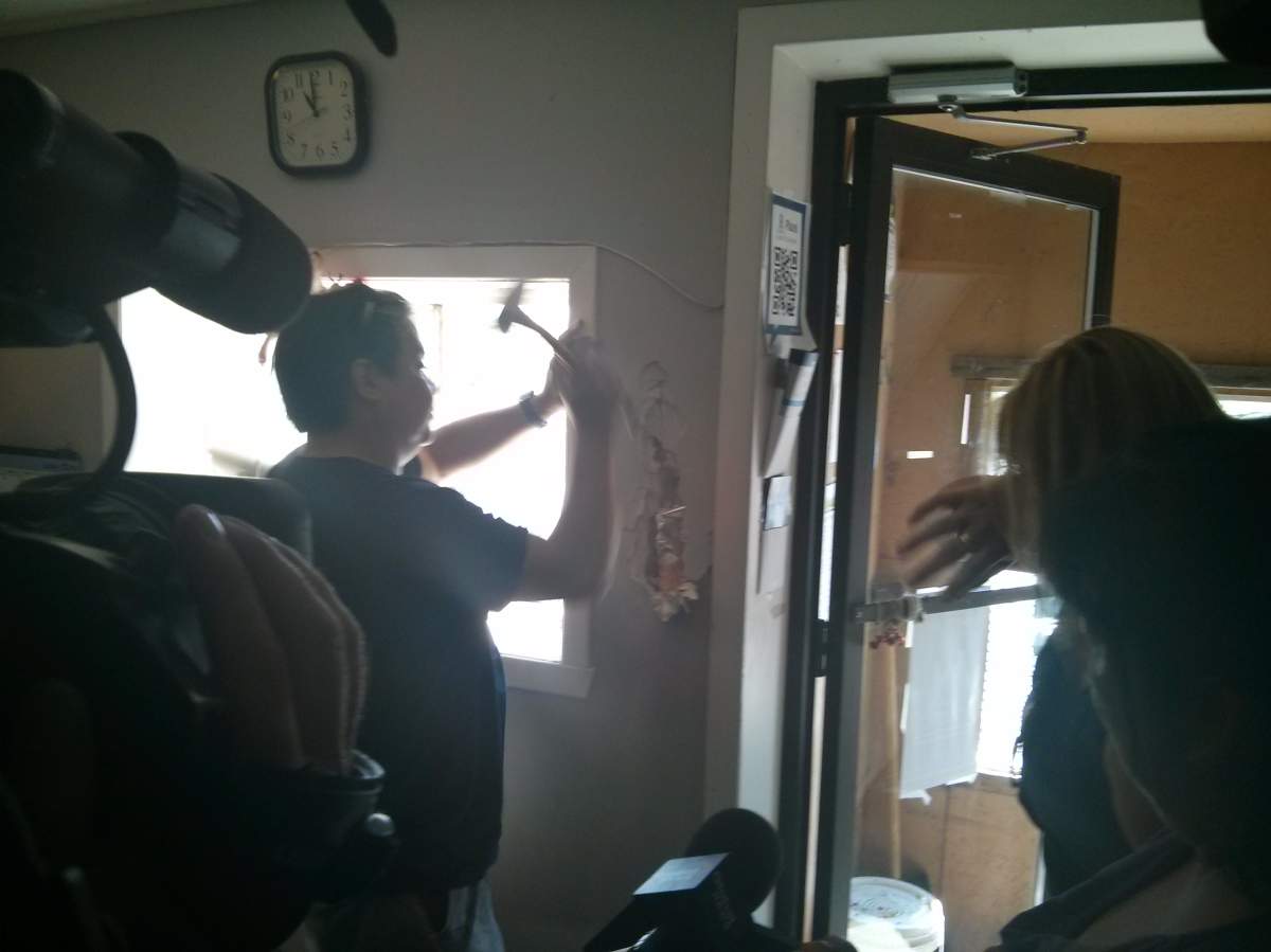 Lance Delisle takes a hammer to the wall in search of a time capsule from 1991 in Kahnawake, Que. on July 11, 2014.