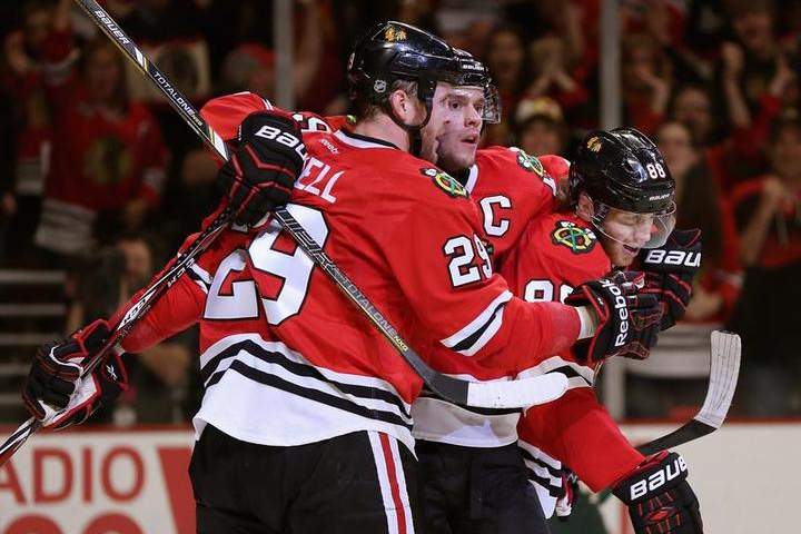 (L-R) Bryan Bickell #29, Jonathan Toews #19 and Partick Kane #88 of the Chicago Blackhawks celebrate Bickell's second period goal against the Minnesota Wild in Game Five of the Second Round of the 2014 NHL Stanley Cup Playoffs at the United Center on May 11, 2014 in Chicago, Illinois.