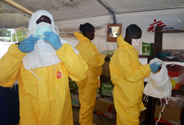 A picture taken on June 28, 2014 shows members of Doctors Without Borders (MSF) putting on protective gear at the isolation ward of the Donka Hospital in Conakry, where people infected with the Ebola virus are being treated. 