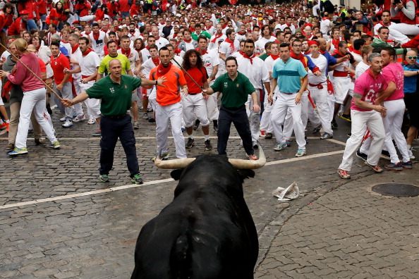 A bull from the Victorio Del Rio Cortes's fighting bulls turns back towards revellers near the end of the run on the fourth day of the San Fermin Running Of The Bulls festival on July 9, 2014 in Pamplona, Spain. The annual Fiesta de San Fermin, made famous by the 1926 novel of US writer Ernest Hemmingway 'The Sun Also Rises', involves the running of the bulls through the historic heart of Pamplona.  (Photo by Pablo Blazquez Dominguez/Getty Images).