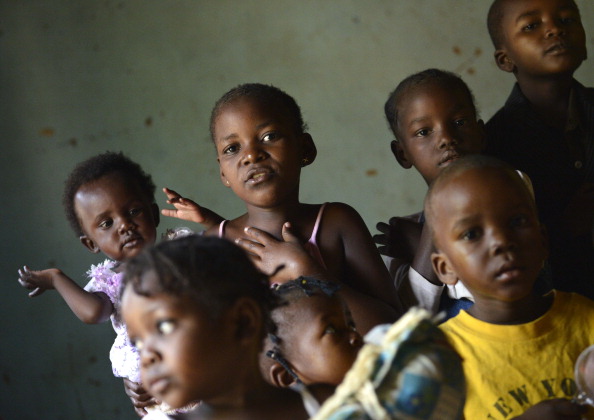 A young girl holds a baby as she stands with other children at the "ONO" orphanage in the Mali-Maka district in the 5th arrondissement of Bangui on January 6, 2014. 