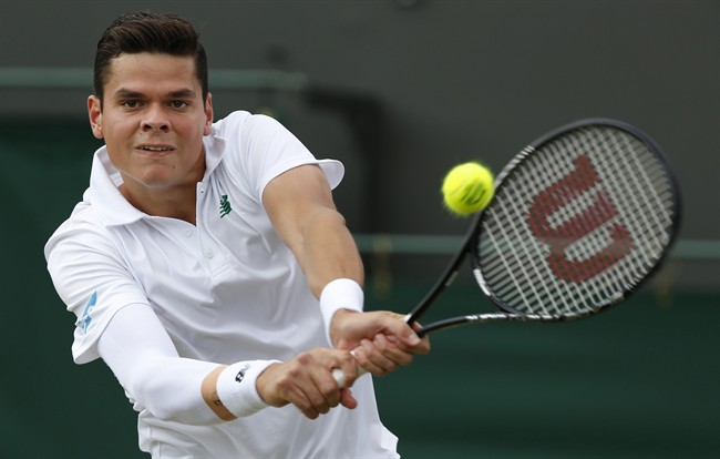 Milos Raonic of Canada plays a return to Kei Nishikori of Japan during their men's singles match at the All England Lawn Tennis Championships in Wimbledon, London, Tuesday, July 1, 2014.