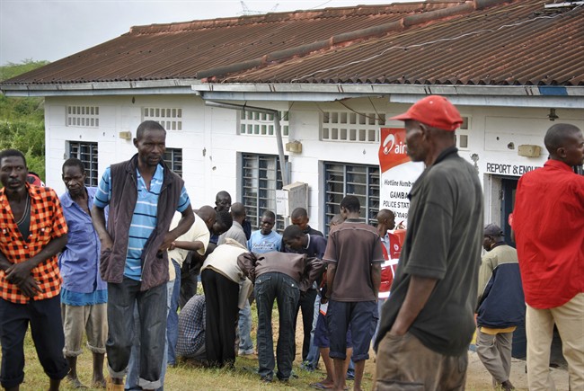 People watch the site where gunmen attacked outside the Gamba police station in Gamba, Kenya, Sunday, July 6, 2014. Eighteen people were killed in overnight attacks by the gunmen in two counties on the Kenyan coast, where last month al-Qaida-linked militants claimed responsibility for killing 65 people, the Kenya Red Cross said Sunday. (AP Photo).