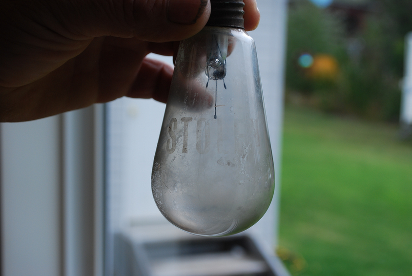 A light bulb from the ghost town of Anyox, with the word "STOLEN" etched on it.