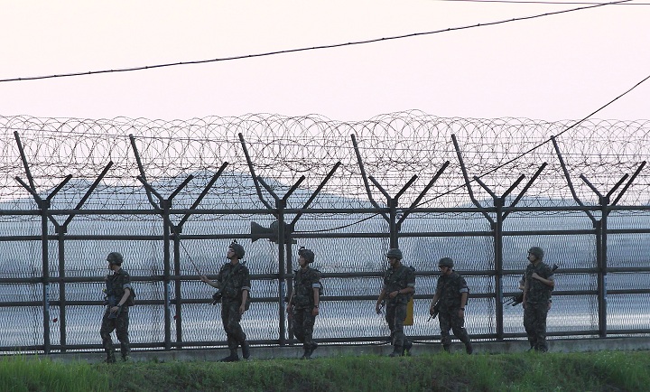South Korean soldiers patrol through the wire fences near the demilitarized zone between the two Koreas in Paju, South Korea, Friday, July 4, 2014. 