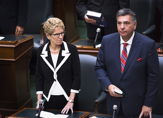 Ontario Premier Kathleen Wynne is sworn in alongside Liberal MPP Charles Sousa during a swearing in ceremony at Queen's Park in Toronto on Wednesday, July 2, 2014. 