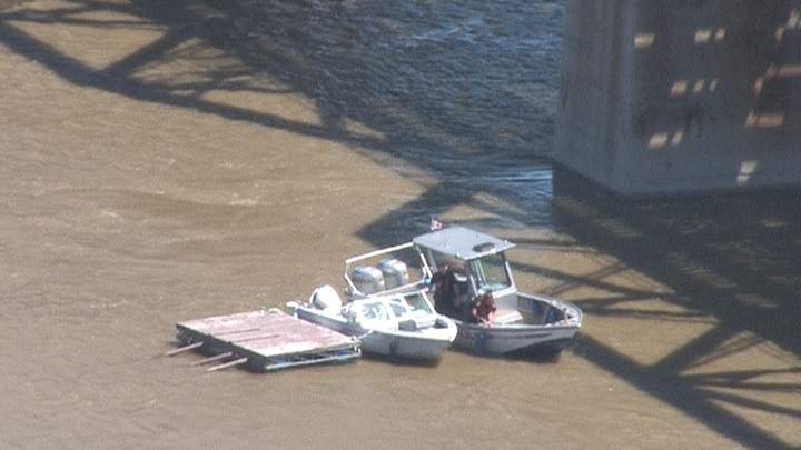 Police river patrol boat takes control of drifting boat and dock on the Red River in Winnipeg on Friday, July 11, 2014