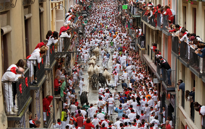 Revellers run with Torrestrella’s fighting bulls along the Calle Estafeta during the second day of the San Fermin Running Of The Bulls festival on July 7, 2014 in Pamplona, Spain.