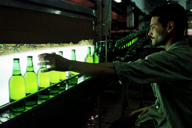 FILE - In this Saturday, July 26, 1997 file photo, an Egyptian worker inspects a bottle of Stella beer rolling down the line at a factory in Cairo, Egypt. On Sunday, July 6, 2014. E.