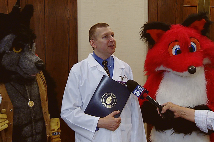 Anthrocon chairman Dr. Samuel Conway flanked by two "furries."