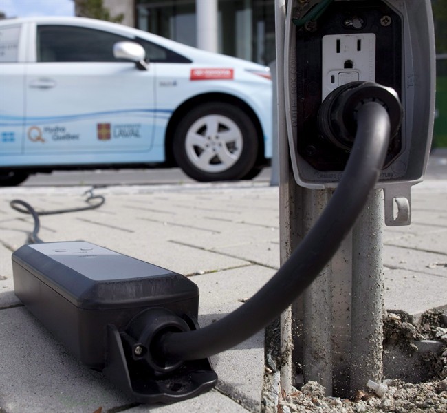 A power cable runs from an electrical outlet to recharge an electric vehicle in downtown Vancouver, B.C. Tuesday, Sept. 14, 2010.