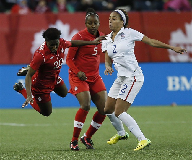 Canada defender Robyn Gayle (5) looks on as Kadeisha Buchanan (20) is fouled by U.S.A. forward Sydney Leroux (2) during second half soccer action of a friendly match in Winnipeg last May. Winnipeg is one of the host venues for the FIFA Women's World Cup this year. Some of the artificial turf surfaces at Canadian venues will have to be replaced, FIFA says.