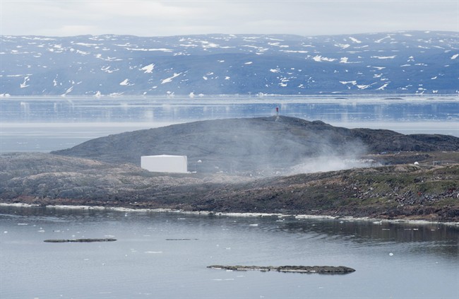 A garbage dump fire smoulders across the bay from the town of Iqaluit, Nunavut, Tuesday, July 8, 2014.