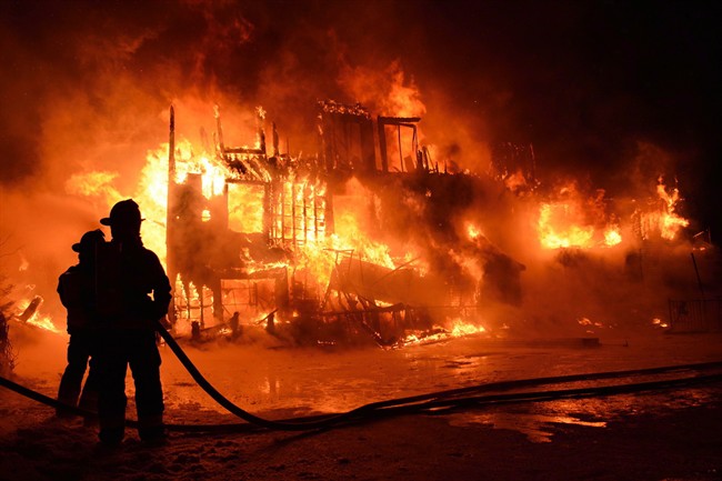 Fire engulfs a seniors residence in L'Isle-Verte, Que., early Thursday, Jan.23, 2014. A multimillion-dollar lawsuit has been filed against the Quebec town where 32 people died in a fire at a seniors' home last January.