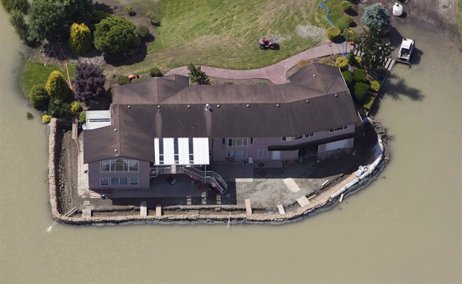 A sandbag dike holds back the water from the Fraser River in Chilliwack, B.C., on June 28, 2012. A streamflow advisory has been issued for the Fraser River.
