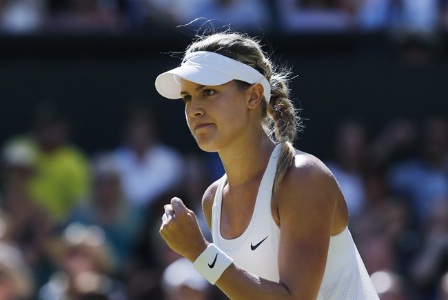 Eugenie Bouchard of Canada celebrates after winning the first set as she plays against Simona Halep of Romania during their women’s singles semifinal match at the All England Lawn Tennis Championships in Wimbledon, London, Thursday, July 3, 2014. (AP Photo/Ben Curtis).