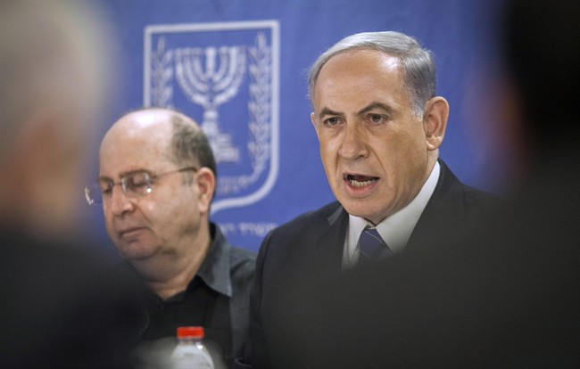 Israeli Defense Minister, Moshe Ya'alon, left, and Israeli Prime Minister Benjamin Netanyahu, center, attend the cabinet meeting at the defense ministry in Tel Aviv, Israel, Thursday, July 31, 2014.