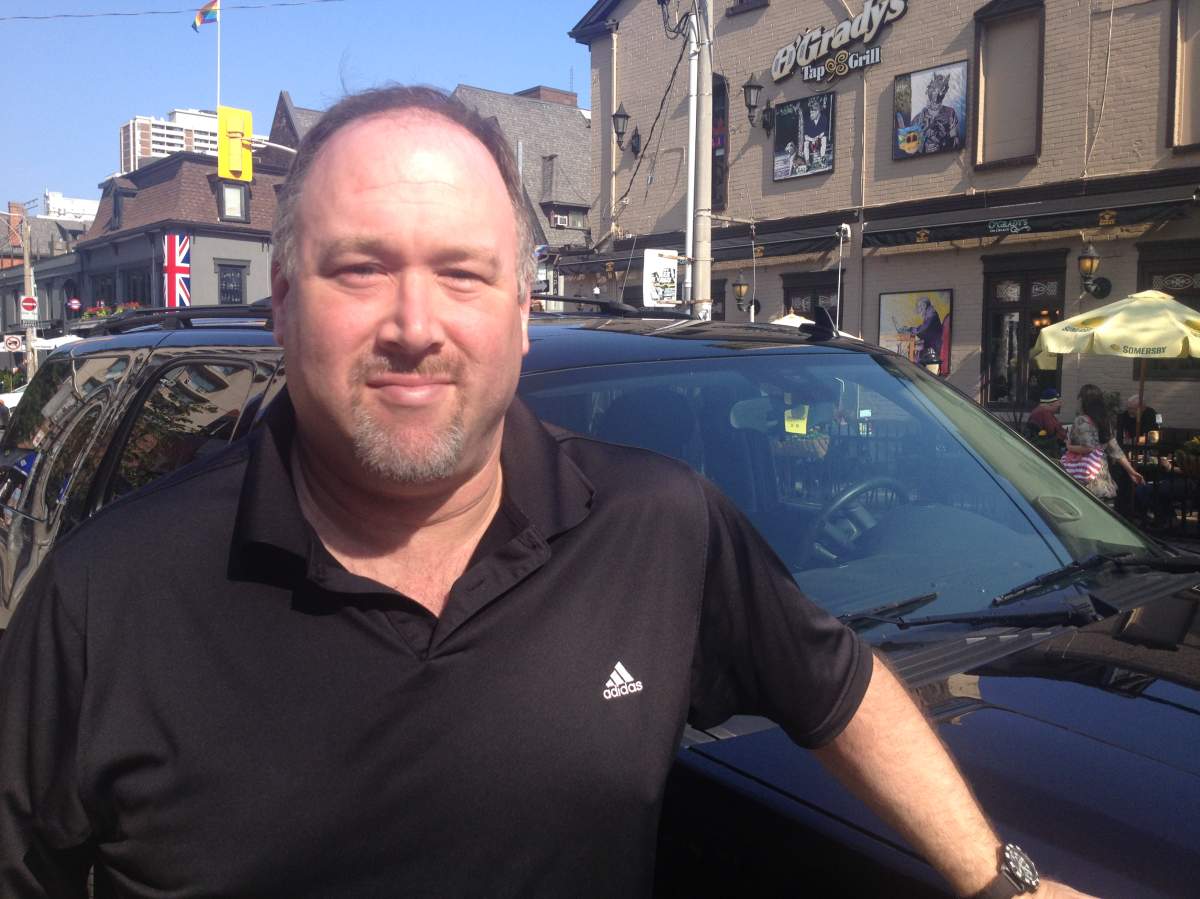 Derrick Snowdy poses with his Chevy Tahoe in downtown Toronto. (Laura Stone/Global News)