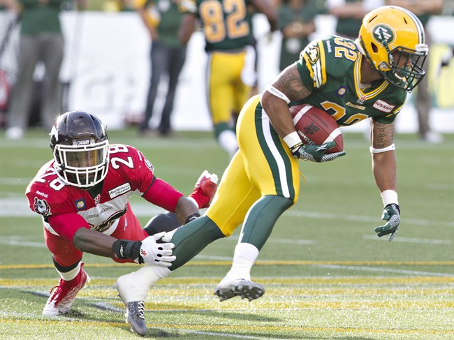 Calgary Stampeders Brandon Smith (28) misses the tackle on Edmonton Eskimos Kendial Lawrence (32) during first half action in Edmonton, Alta., on Thursday July 24, 2014. 