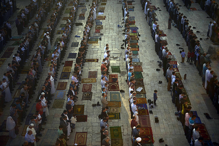 Muslim worshippers pray during the first day of Eid al-Fitr, which marks the end of the Muslim fasting month of Ramadan, at the Al Aqsa Mosque compound in Jerusalem’s Old City, Monday, July 28, 2014.