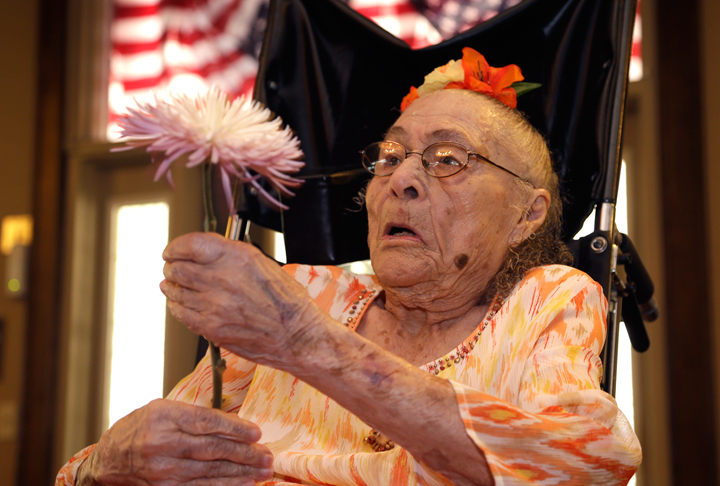 Gertrude Weaver holds a flower given to her a day before her 116th birthday, at Silver Oaks Health and Rehabilitation Center in Camden, Ark., Thursday, July 3, 2014. The Gerontology Research Group says Weaver is the oldest person in the United States and second-oldest person in the world.