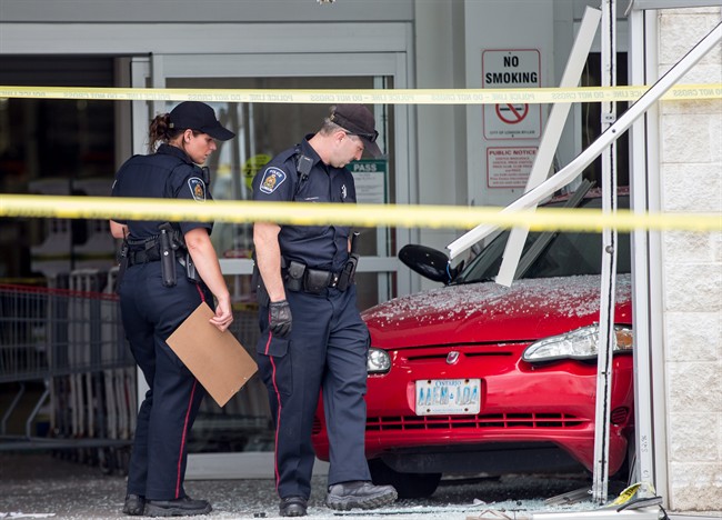 Police investigate after a car backed through the entrance of Costco in London, Ont., on Friday, July 25, 2014.
