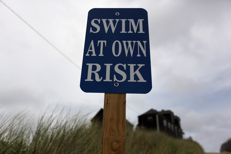 A sign reads 'Swim at Own Risk' at Ballston Beach on Cape Cod on August 12, 2012 in Truro, Massachusetts. (Photo by Mario Tama/Getty Images).