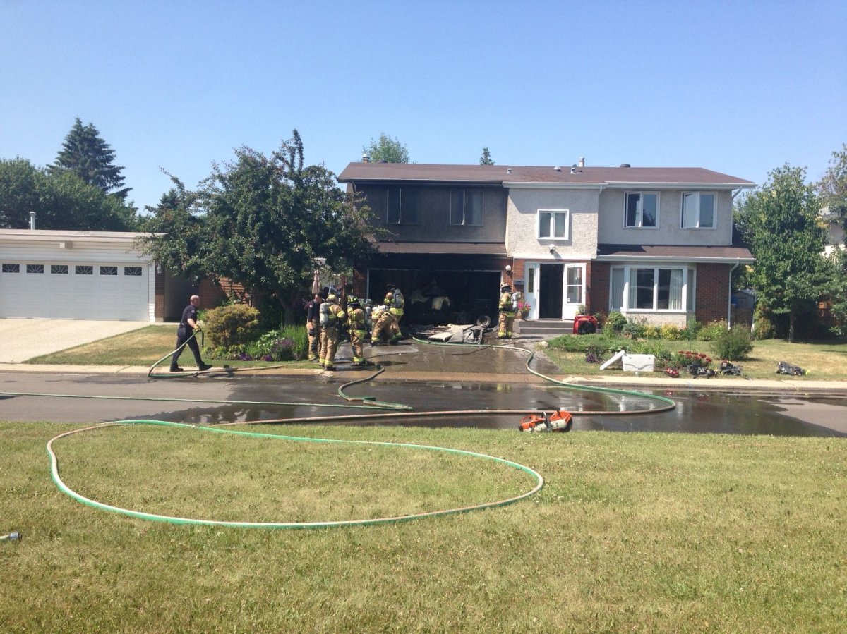 Edmonton firefighters battle a blaze at a home in south Edmonton, Sunday, July 13, 2014. 