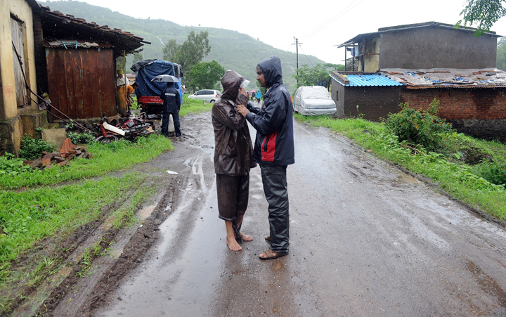 A villager (L) mourns with a neighbour following a landslide at Malin village in Pune district of India’s western state of Maharashtra on July 31, 2014.