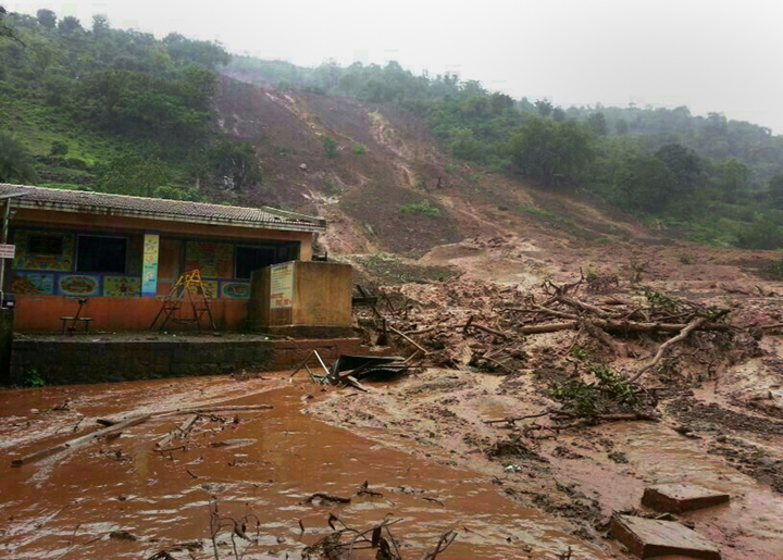 A mudslide surrounds a building in Malin village in Pune district the western Indian state of Maharashtra on July 30, 2014.