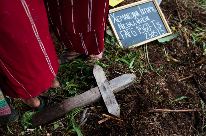 In this May 23, 2013 photo, Ixil Mayan women gather around a mass grave where forensic anthropologists exhume the remains of their loved ones who died during the country's civil war, near Ixtupil, Guatemala. 