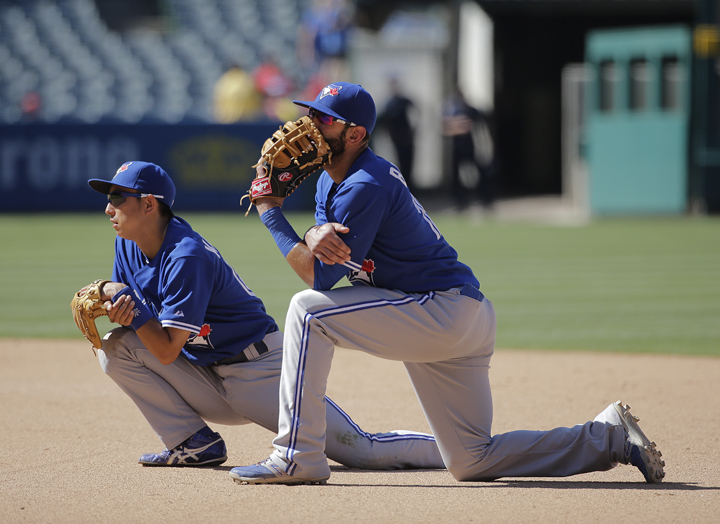 Toronto Blue Jays' Jose Bautista, center, and Munenori Kawasaki, of Japan, kneel on the field during the ninth inning of a baseball game against the Los Angeles Angels on Wednesday, July 9, 2014, in Anaheim, Calif. 