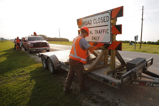 Manitoba infrastructure crews prepare to shut down highway 331 to the Hoop And Holler Bend near Portage La Prairie, Man., on Friday, July 4, 2014.