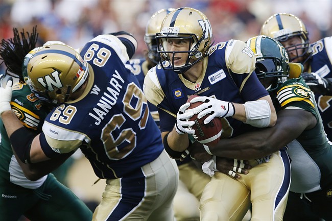 Blue Bombers quarterback Drew Willy (5) gets hauled down by the Eskimos' Almondo Sewell (90) in Winnipeg Thursday, one of five sacks during a 26-3 drubbing by Edmonton.