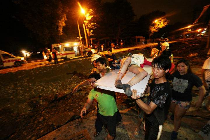 Residents carry a wounded person following a blast in the city of Kaohsiung in southern Taiwan early on August 1, 2014