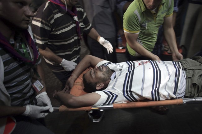 A wounded Palestinian is carried into Shifa hospital in Gaza City, northern Gaza Strip, early Friday, July 18, 2014. The heavy thud of tank shells, often just seconds apart, echoed across the Gaza Strip early Friday as thousands of Israeli soldiers launched a ground invasion, escalating a 10-day campaign of heavy air bombardments to try to destroy Hamas' rocket-firing abilities and the tunnels militants use to infiltrate Israel. (AP Photo/Khalil Hamra).