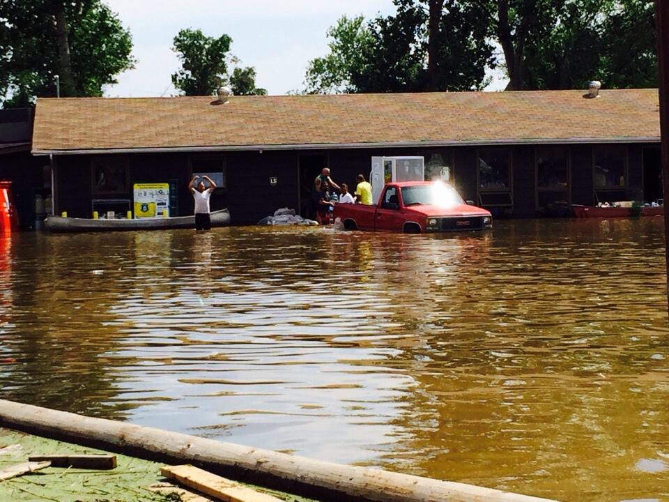 Property owners try to save their possessions as flood waters rise at Crooked Lake on July 4, 2014.