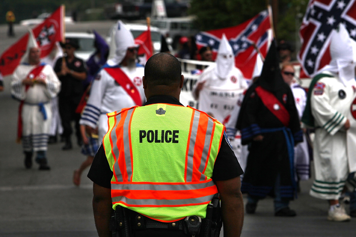 File photo - A police officer watches as members of the Fraternal White Knights of the Ku Klux Clan participate in the 11th Annual Nathan Bedford Forrest Birthday march July 11, 2009 in Pulaski, Tennessee.