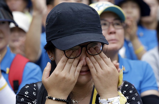 A family member of a victim of the sunken ferry Sewol wipes her tears during a rally 100 days after the ferry sunk in Seoul, South Korea, Thursday, July 24, 2014. 