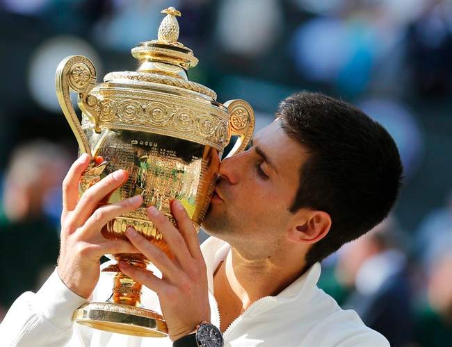 FILE – In this Sunday July 6, 2014 file photo, Novak Djokovic of Serbia kisses the trophy after defeating Roger Federer of Switzerland in the men\’s singles final at the All England Lawn Tennis Championships in Wimbledon, London.