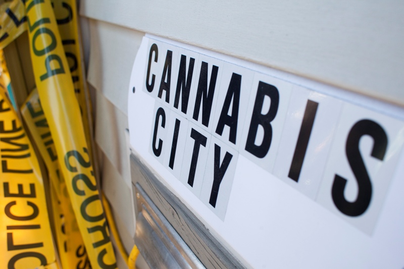 A sign is pictured near police tape, which was used as a prop for a ribbon cutting ceremony, at Cannabis City, a retail marijuana store, on July 8, 2014 in Seattle, Washington. (Photo by David Ryder/Getty Images).