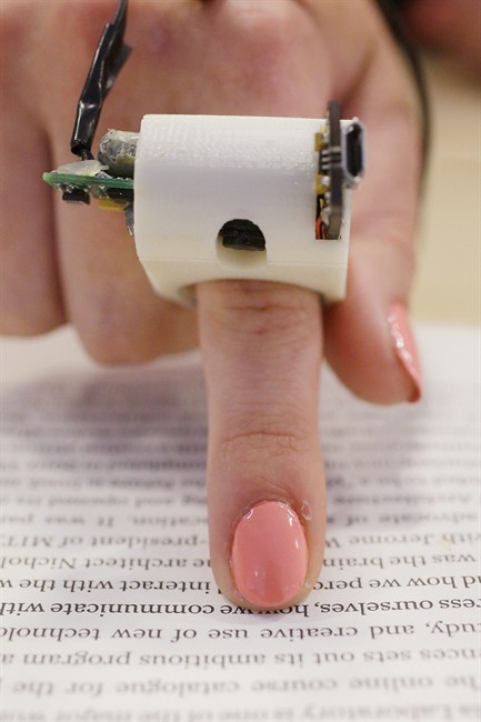 A model wears a FingerReader ring at the Massachusetts Institute of Technology's Media Lab in Cambridge, Mass. Researchers designed and developed the instrument, which enables people with visual disabilities to read text printed on paper or electronic devices.