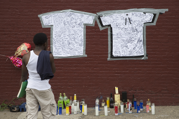 A pedestrian stands at a memorial to Lawrence Campbell, who allegedly shot and killed 23-year-old Jersey City police officer Melvin Santiago, Monday, July 14, 2014, in Jersey City, N.J. 