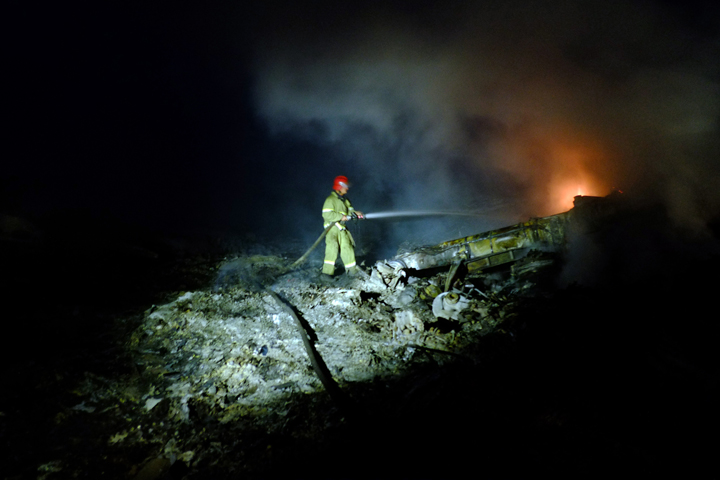 9: A firefighter sprays water to extinguish a fire, on July 17, 2014 amongst the wreckage of the Malaysian airliner carrying 298 people from Amsterdam to Kuala Lumpur after it crashed, near the town of Shaktarsk, in rebel-held east Ukraine. Dominique Faget/AFP/Getty Images