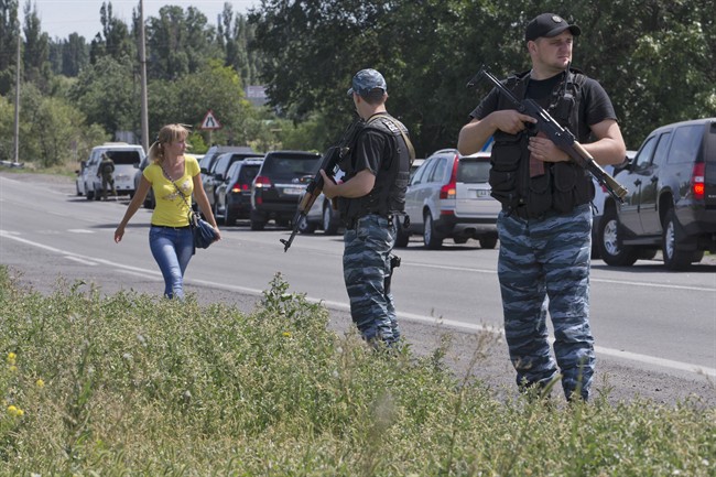 Self-proclaimed Donetsk People's Republic policemen guard a convoy of international forensic experts, Dutch and Australian policemen and members of the Organization for Security and Cooperation in Europe mission in Ukraine, as it approached Shakhtarsk, Donetsk region, eastern Ukraine, on Monday, July 28, 2014.